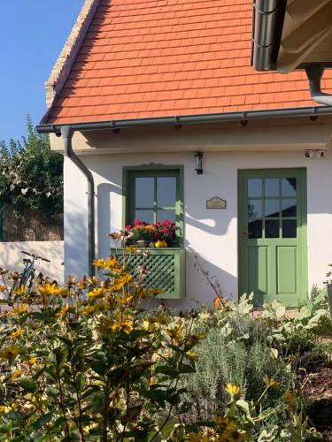 a house with a green door and a flower box at Pannonhalma Várlak Vendégház Demeter Lak in Pannonhalma