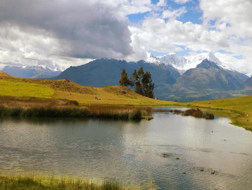 a body of water with mountains in the background at mountain view willcacocha lodge in Huaraz