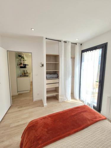 um quarto com uma cama e uma grande janela em Paisible, spacieux avec petit jardin em Artigues-près-Bordeaux