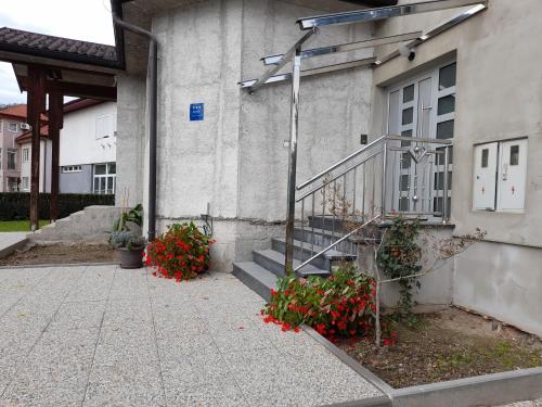 a building with stairs and flowers in front of it at Opatovina in Topusko