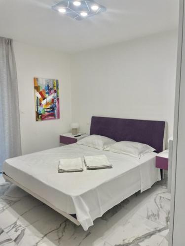 une chambre avec un grand lit avec deux serviettes dessus dans l'établissement Saint Jhon, à Menton