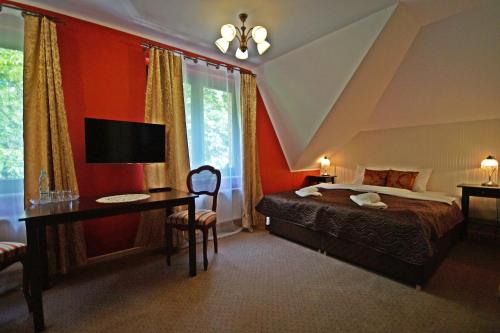 a bedroom with a bed and a desk and a tv at Balia Spa & Wellness in Kazimierz Dolny