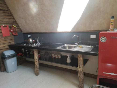 Hostal Macal في تالكا: مطبخ مع مغسلة وثلاجة حمراء