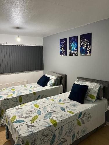 two beds sitting next to each other in a bedroom at Berwickshire House in Marston Green