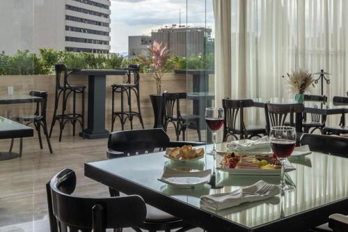 una mesa con copas de vino y comida en el balcón en Hotel Elements by Marquis, en Ciudad de México