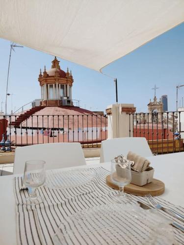 een tafel met witte stoelen en een vuurtoren op de achtergrond bij Antigua Casa Hermandad in Sevilla