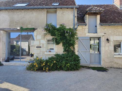 una casa con una puerta azul y algunas flores en Gîte Les Piraudières, en Noyant-de-Touraine