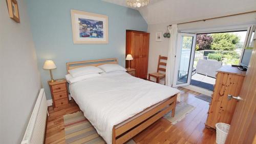 a bedroom with a large bed and a balcony at Tichbourne Street, Mumbles in The Mumbles