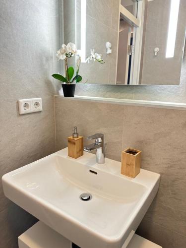 um lavatório branco na casa de banho com um espelho em Green Paradise & Cozy Retreat Salzburg with free parking em Salzburgo