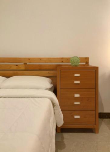 a bedroom with a bed and a wooden dresser at SEACOAST HOTEL AND RESORTS in Mactan