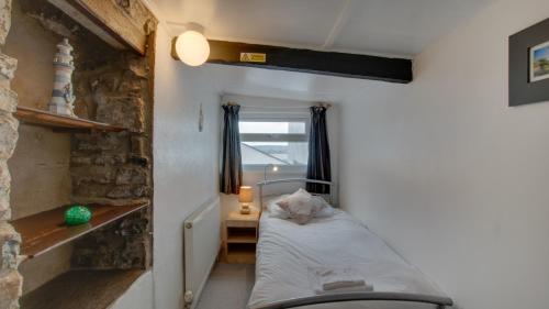 een kleine kamer met een bed en een raam bij Little Hill House, Mumbles in The Mumbles