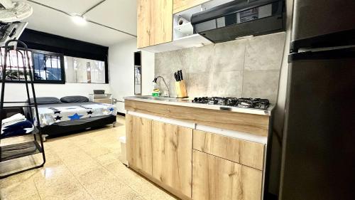 a kitchen with a stove and a bed in a room at Malibu loft hotel in Medellín