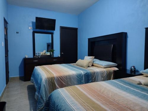 um quarto azul com 2 camas e um espelho em Hotel Prado´s em San Carlos