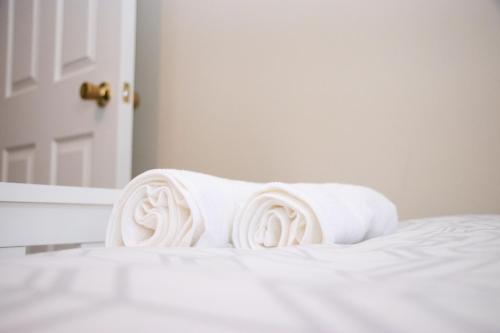 einen Stapel weißer Handtücher auf dem Bett in der Unterkunft Reading Spacious Stay, NHS & Contractors in Reading