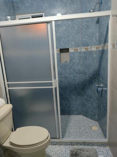 a bathroom with a glass shower with a toilet at Hotel Prado´s in San Carlos