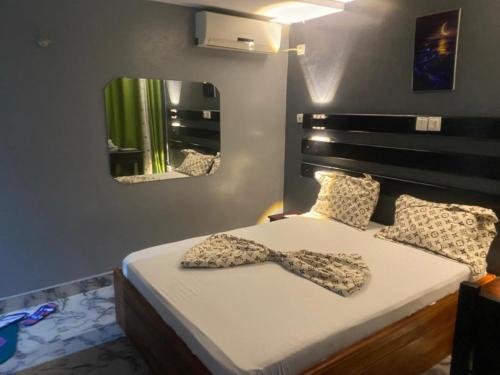 a bedroom with a bed with a bow tie on it at Sunrise Center Bonapriso - 109 in Douala