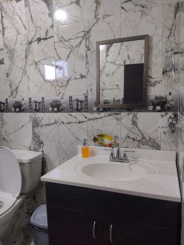 Hotel Prado´s في San Carlos: حمام مع حوض ومرحاض ومرآة