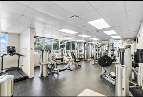 a gym with treadmills and machines in a room at Ramada Marco Polo in Sunny Isles Beach