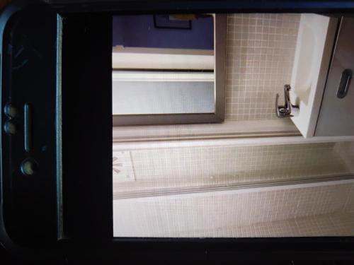 een raam in een badkamer met witte tegels bij Tiny cosy flat in Lissabon