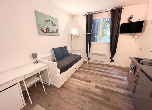Elle comprend un petit salon avec un canapé et un bureau. dans l'établissement Good mood, à Bordeaux
