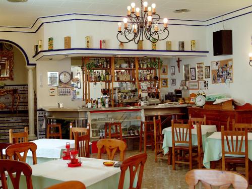 a restaurant with tables and chairs and a bar at Hostal San Francisco in Campillos