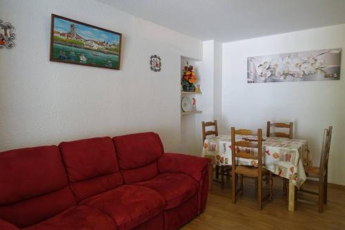 a living room with a red couch and a table at Ha-Py Friends in Campan