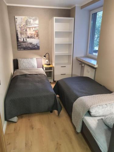 a bedroom with two beds and a window at JDK Apartamenty Legionów 74m2 8-osobowy in Kalisz