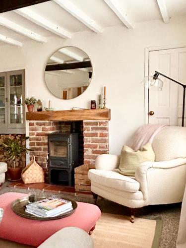 sala de estar con silla y chimenea en Charming 3 bedroom house in Woodbridge area, en Grundisburgh