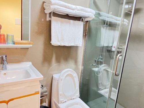 ein Bad mit einer Dusche, einem WC und einem Waschbecken in der Unterkunft Beachfront U.S. Embassy Family Retreat. in Manila