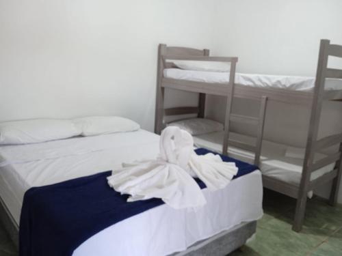 2 letti in una camera con 2 letti a castello e asciugamani di Pousada Capitour a São José da Barra