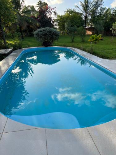 uma piscina com água azul num quintal em Casa Vagalume - 10 minutes to secluded beach em Pôrto de Pedras