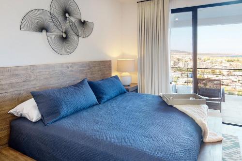 a bedroom with a blue bed and a balcony at Montemar D 502 in Cabo San Lucas