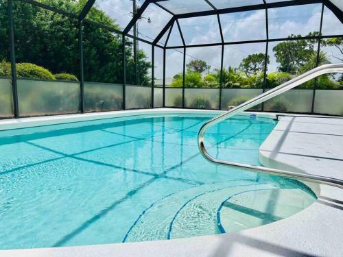 a large swimming pool with a metal structure at Oasis Away Englewood, Florida! Spacious home w/ heated pool in Englewood