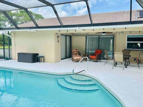 a swimming pool in a patio with a table and chairs at Oasis Away Englewood, Florida! Spacious home w/ heated pool in Englewood