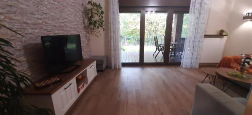 a living room with a flat screen tv and a couch at Apartament Willa Port "Kaczorek" in Ostróda