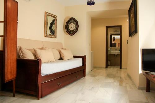 un soggiorno con divano e orologio sul muro di Apartamentos Medina Qurtuba a Cordoba