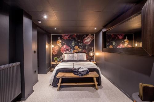 1 dormitorio con 1 cama con una pintura en la pared en Le Terrier Ovifat - Appartement entier Familial - Sauna & Massage, en Ovifat