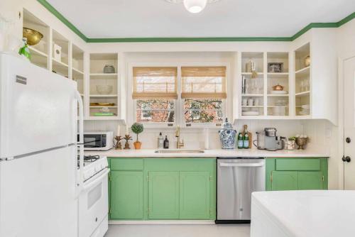 a kitchen with green cabinets and a white refrigerator at The Grand Millennial in Downtown Charleston in Charleston