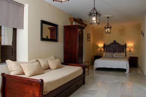 コルドバにあるApartamentos Medina Qurtubaのベッドルーム1室(ベッド1台、ソファ付)