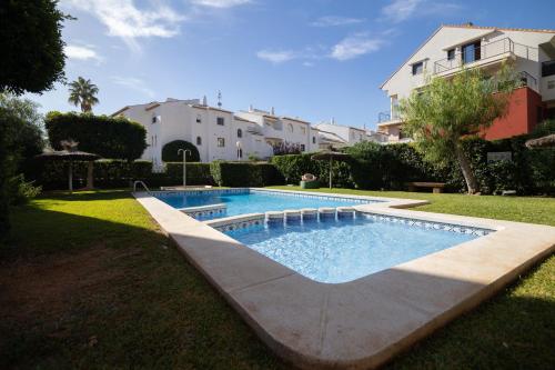 a swimming pool in the yard of a house at Jávea terraza + piscina + vistas al mar in Platja de l'Arenal