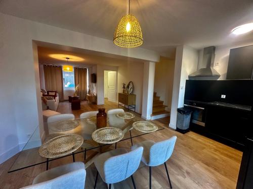 - un salon avec une table en verre et des chaises blanches dans l'établissement Le Reposoir XXL avec jacuzzi, à Boulogne-sur-Mer