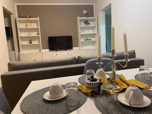 a living room with a table with hats and candles at Lux Apartment Vivo Mall in Baia Mare