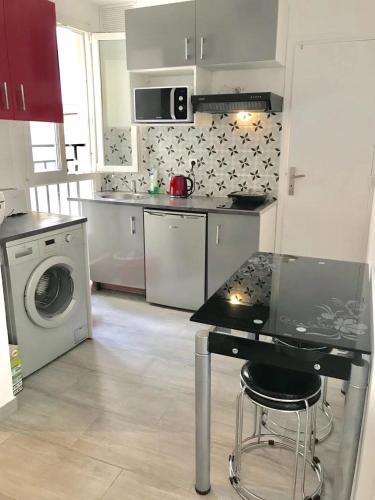 une cuisine avec une table et une machine à laver dans l'établissement Bastillle two bedroom APT, à Paris