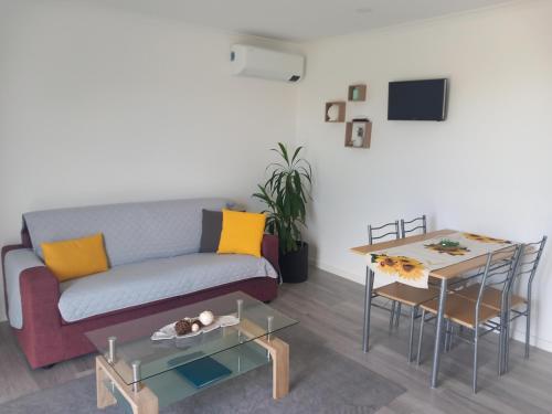 a living room with a couch and a table at Villa - Sleeps 4 & Free Parking in Ribeira Grande