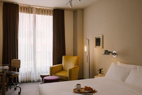 um quarto de hotel com uma cama e uma cadeira em Chambers powered by Sonder em Nova Iorque
