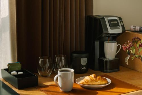 einen Tisch mit Kaffeemaschine und Teller mit Essen in der Unterkunft Chambers powered by Sonder in New York