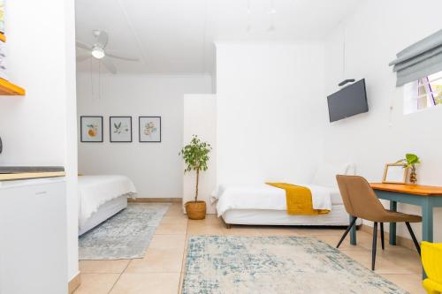 a room with two beds and a desk and a table at The Yellow Door Guesthouse in East London