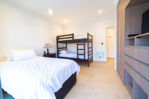 a bedroom with two bunk beds and a television at Pinares de Higuerillas in Maitencillo
