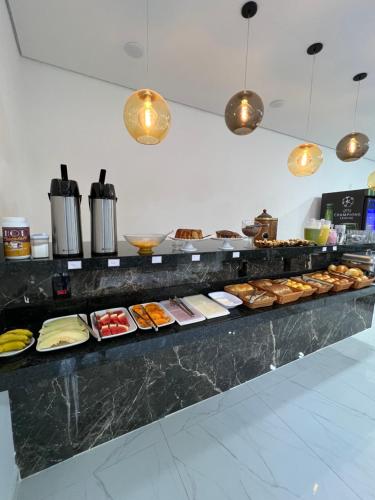 un buffet avec de nombreux types de nourriture différents dans l'établissement Hotel Pousada Colliseu, à Aparecida
