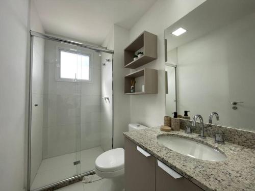 a bathroom with a shower and a sink and a toilet at Apto Vilage Puc in Porto Alegre